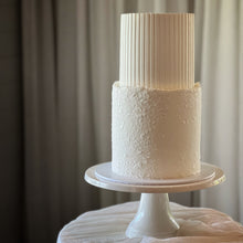 Load image into Gallery viewer, Two-tier stucco and fluted cake with textured base and smooth vertical detailing