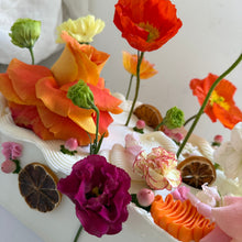 Load image into Gallery viewer, Close-up view of the fresh garden flowers, piped ganache textures, pearl details and dried citrus decorating the Floral Chaos Slab Cake.