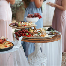 Load image into Gallery viewer, Outdoor gathering with a food display on a table, people in the background
