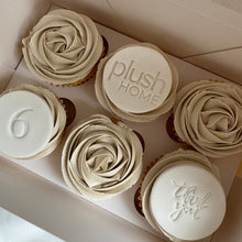 Load image into Gallery viewer, Vanilla mud cake cupcakes with white chocolate truffle frosting and custom logo fondant discs