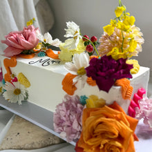 Load image into Gallery viewer, Close-up of a long table cake with floral decoration and textured buttercream