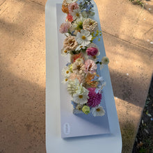 Load image into Gallery viewer, Floral arrangement on a white rectangular cake outdoors