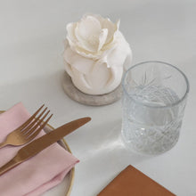 Load image into Gallery viewer, Small white floral mini cake with sculpted petals on a marble base, placed beside glassware and cutlery at a styled table setting at blanca newcastle, part of Spodeli Mini Series