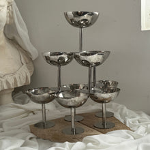 Load image into Gallery viewer, Polished silver coupes arranged in a three-tier tower on travertine with ivory fabric.