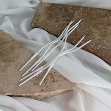 Load image into Gallery viewer, Close-up of slim white wavy candles showing sculptural curved shape