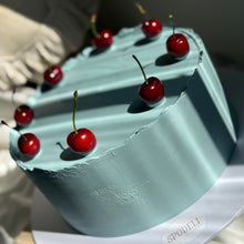 Load image into Gallery viewer, Top view of The European Cherry Edit cake showing cherry detail and smooth blue ganache finish by Spodeli
