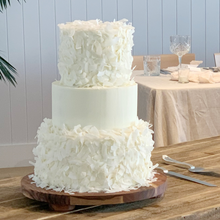 Load image into Gallery viewer, Close-up of hand-applied coconut flake texture on a tiered cake