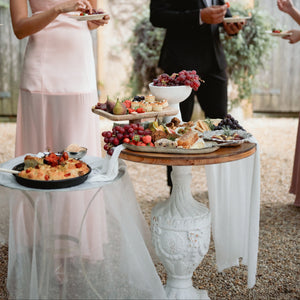 People serving themselves from a buffet table outdoors.