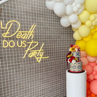 Decorative setup with balloons, cake, and 'Til Death Do Us Party' sign.