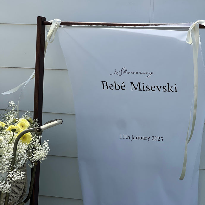 White banner with text on a stand outdoors