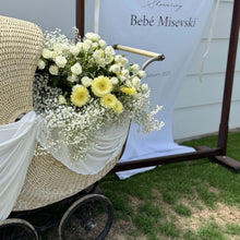 Load image into Gallery viewer, Vintage-style pram with flowers in front of a backdrop with &#39;Bébé Misevski&#39; text.
