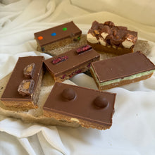 Load image into Gallery viewer, Assorted chocolate slices on a white fabric background
