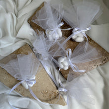 Load image into Gallery viewer, Sugared almond bonbonniere arranged on stone with soft fabric styling
