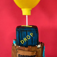 Fortnite supply drop cake with balloon topper and fully sculpted two-tier novelty design by Spodeli 