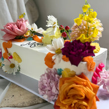 Load image into Gallery viewer, Close-up of a long table cake with floral decoration and textured buttercream
