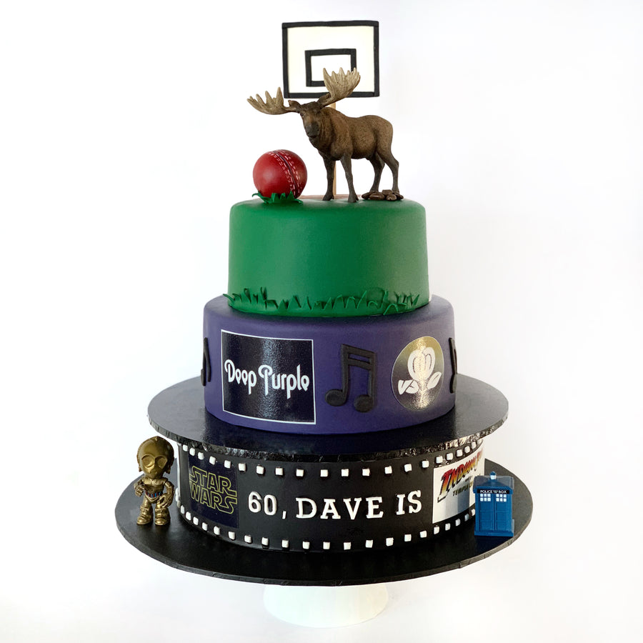 Three-tiered cake with moose, sports ball, and 'Deep Purple' elements on a white background