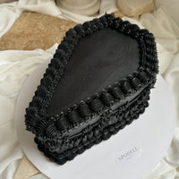 Angled view of a coffin cake highlighting piped border detailing and shape
