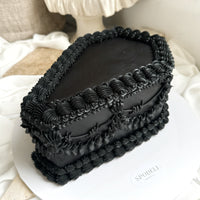 Black Coffin shaped cake with detailed hand piping and sculptural form