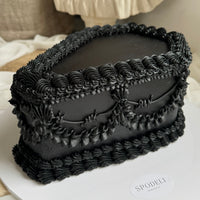 Side view of a coffin cake with layered hand piping and structured finish