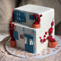 Mediterranean style house cake with stucco walls, blue doors and bougainvillea vines
