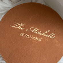 Load image into Gallery viewer, Large round tiramisu wedding dessert cake with cocoa top and “The Mitchells 01.03.2026” stencil
