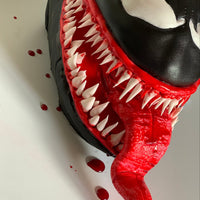 Close-up of sculpted Venom cake by Spodeli showing hand-placed teeth and red tongue detail