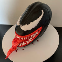 Sculpted Venom cake by Spodeli with extended tongue and detailed teeth, photographed from above