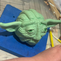 Behind-the-scenes view of a hand-sculpted Yoda cake in progress