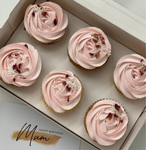 Load image into Gallery viewer, A photo showing cupcakes with a standard swirl white chocolate truffle topping, iced and decorated in line with a color theme.
